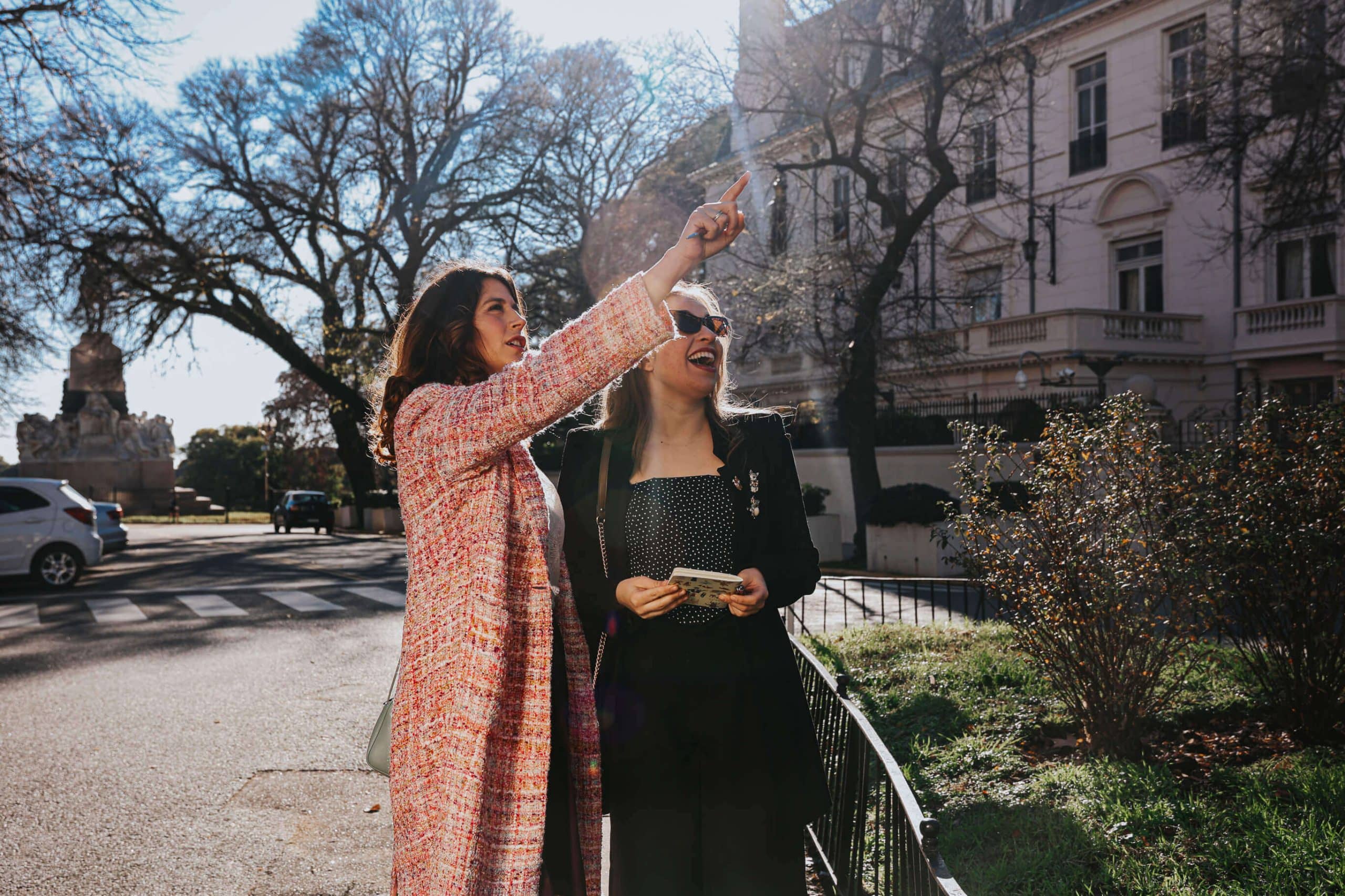 Sole Plazas, fundadora de HeySole!, señalando un detalle arquitectónico en Buenos Aires durante un recorrido cultural con una viajera